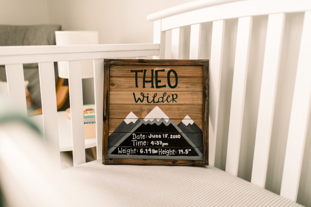 Baby birth announcement with baby's name, date of birth and time, and weight and height. Sign is in baby's crib. 